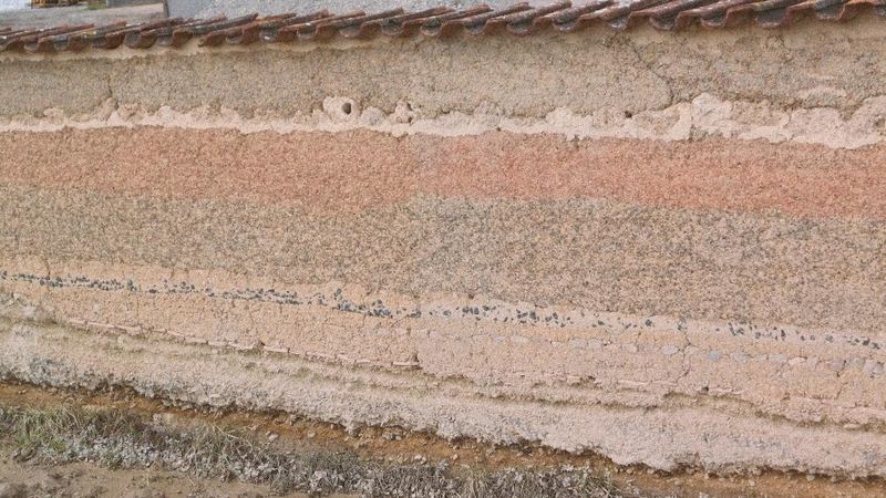 Stampflehmwand in verschiedenen Farben als Grundstücksbegrenzung